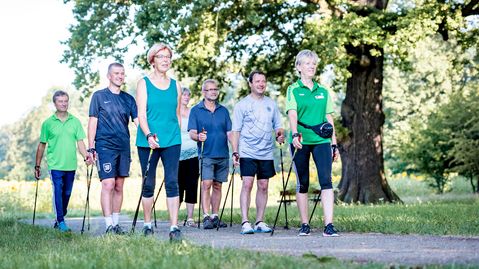 Herzsportgruppe bei Herzerkrankungen Herzsportgruppe beim Nordic Walking im Grünen.