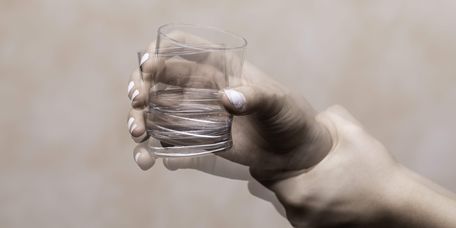 Zitternde Hand mit Glas