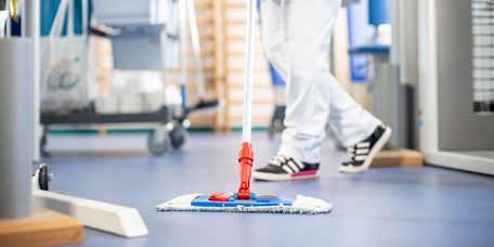 Eine Reinigungskraft wischt den Boden in einem Operationssaal