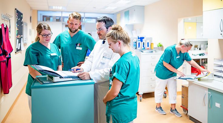 Arzt und Pflegekräfte besprechen Patientenakten