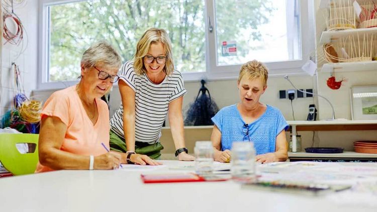 Therapeutin mit Patientinnen bei der Maltherapie