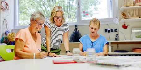 Therapeutin mit Patientinnen bei der Maltherapie