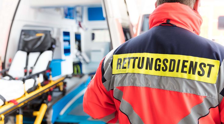 Ein Sanitäter steht vor dem geöffneten Krankenwagen
