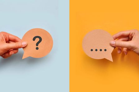 Hände halten jeweils ein Fragezeichen- und ein Antwortkärtchen