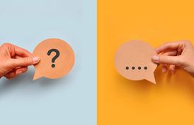 Hände halten jeweils ein Fragezeichen- und ein Antwortkärtchen