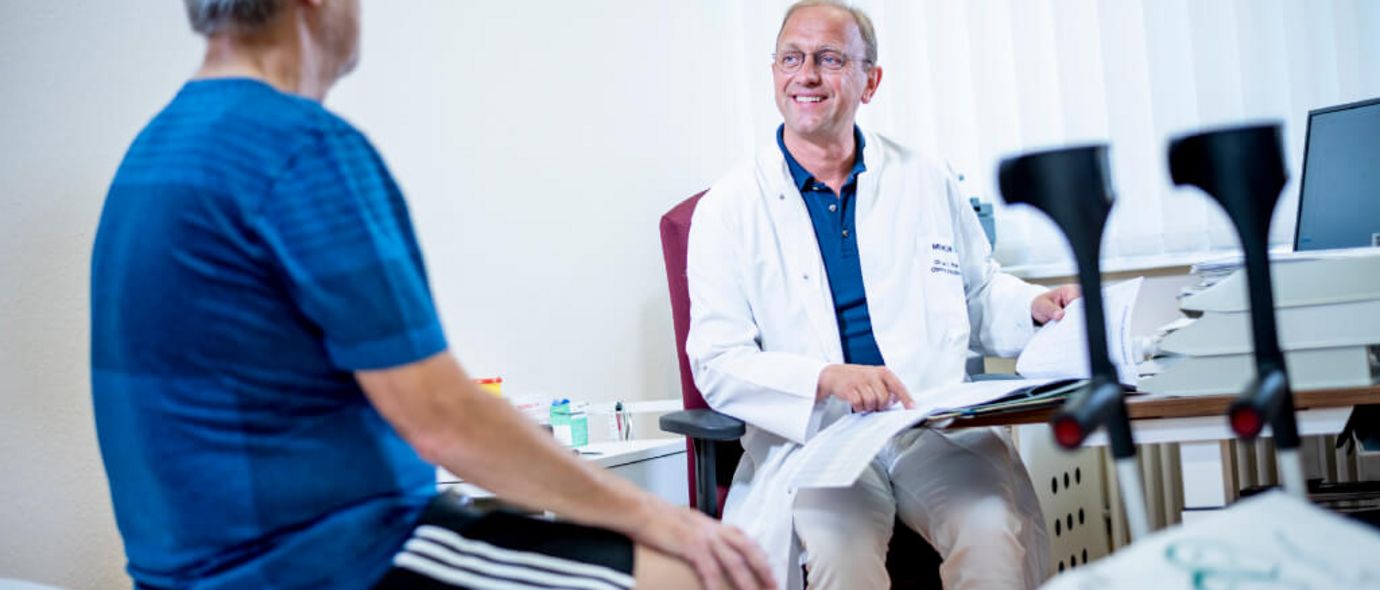 Arzt spricht mit Patinten in der Orthopädie