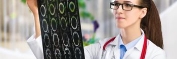 Ärztin analysiert MRT-Aufnahmen eines menschlichen Kopfes