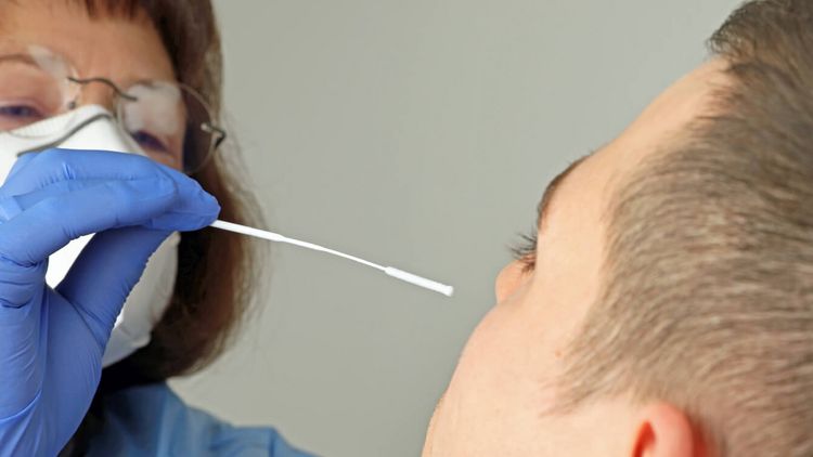 Pflegekraft macht einen Nasenabtrich bei einem Patienten