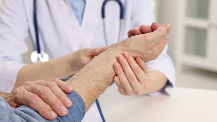 Arzt untersucht den Arm eines Patienten